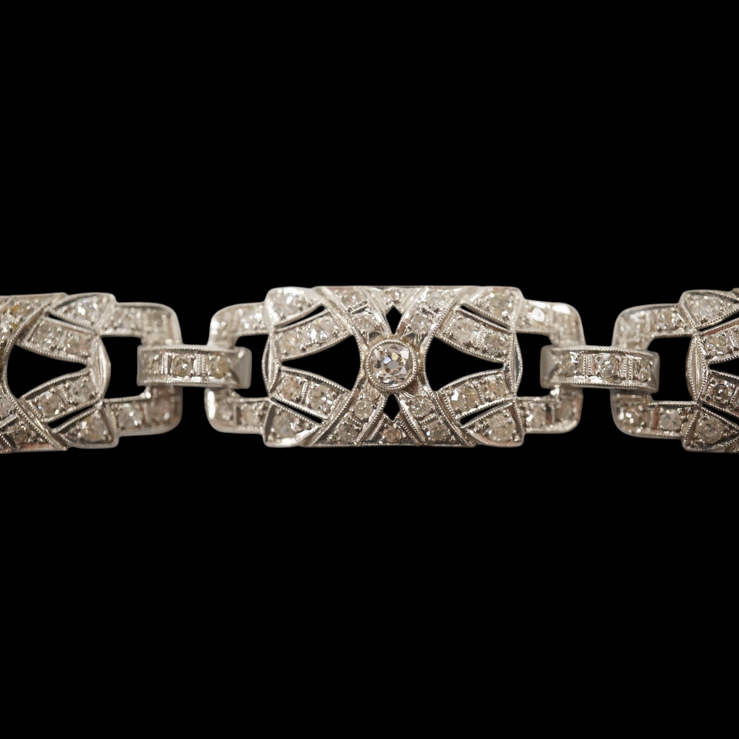 An early 20th century pierced platinum? and millegrain set diamond cluster bracelet, set with old round and eight cut stones, 17cm, gross weight 22.8 grams. Condition - fair to good